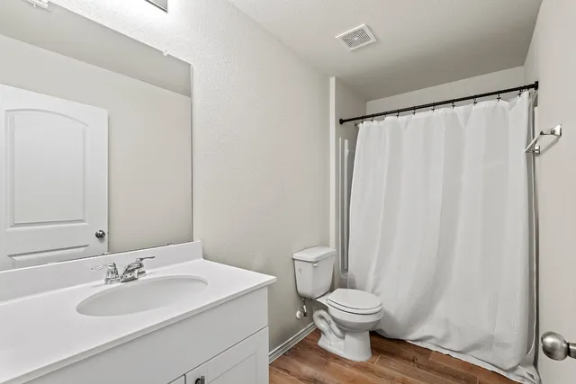 a bathroom with a toilet a sink and a mirror