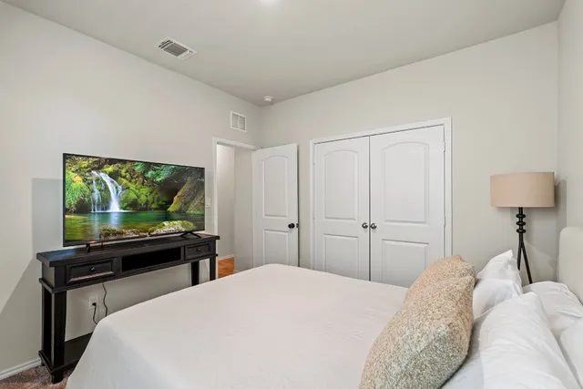 a bedroom with a bed and a flat screen tv