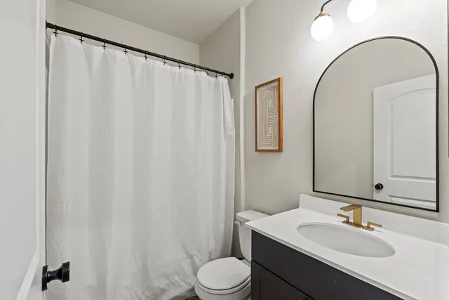 a bathroom with a sink vanity mirror and toilet