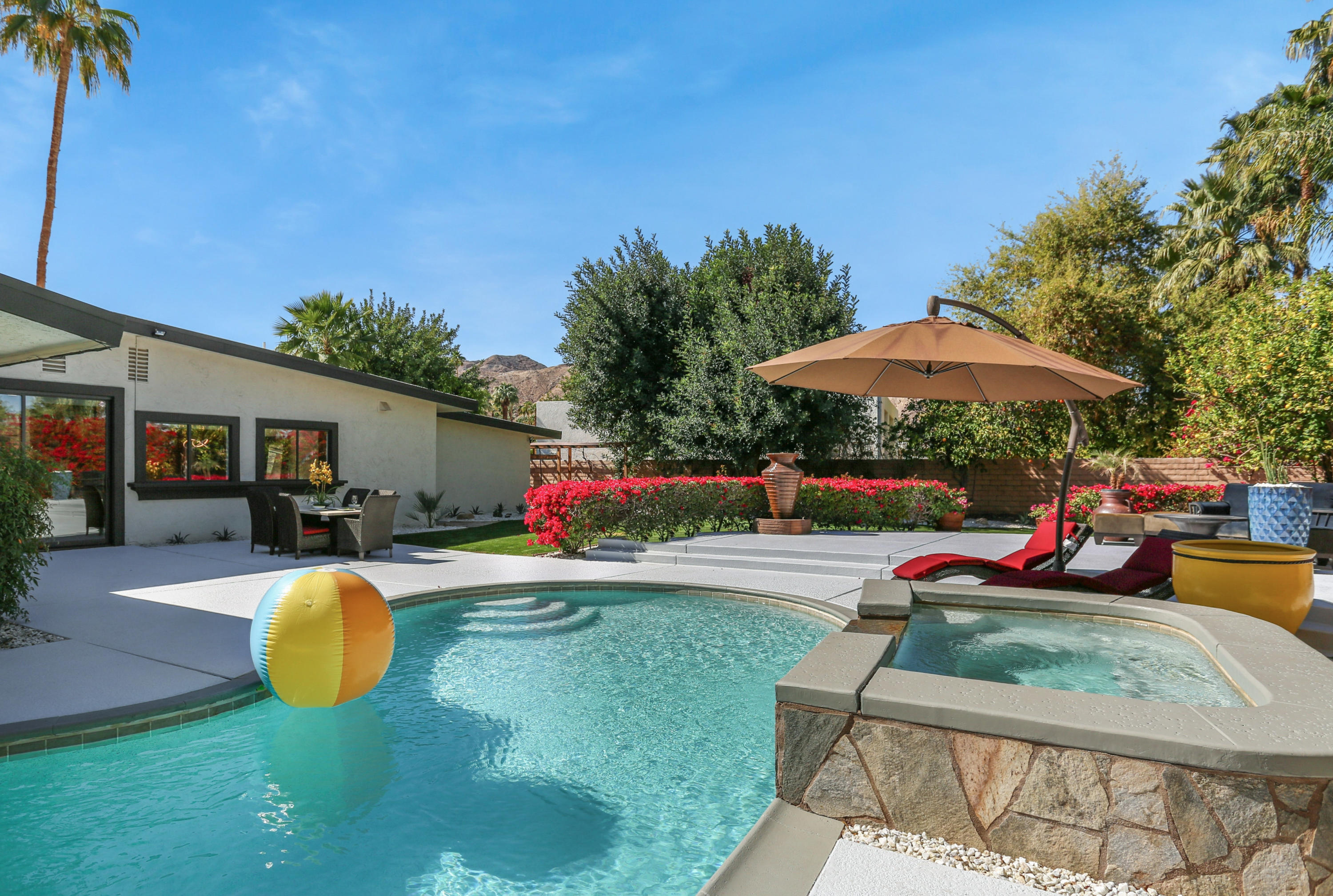71480 Halgar Road Rancho Mirage, CA 92270 - Photo 31 of 52 a view of a swimming pool with a table and chairs under an umbrella