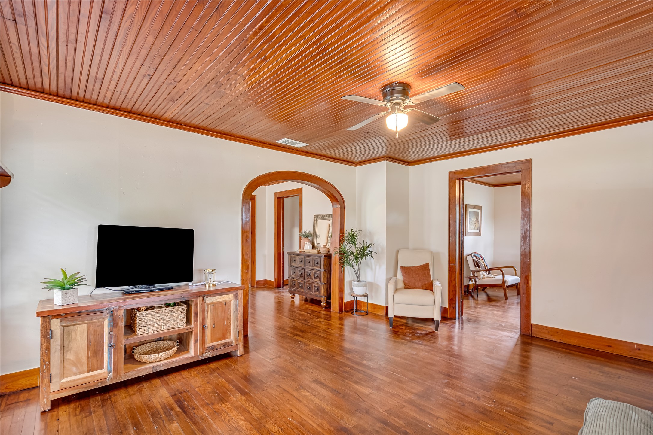 4022 Crosby Cedar Bayou Road Baytown, TX 77521 - Photo 7 of 43 Another view of the living room—beadboard ceiling, hardwoods, and sightlines to Bedroom 3/office and the arched entry to the dining room.