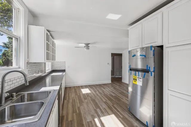 a kitchen with granite countertop white cabinets and window
