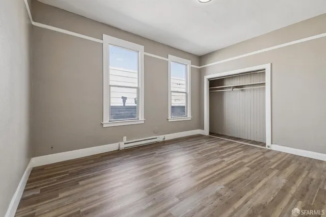 a view of an empty room with closet and a window