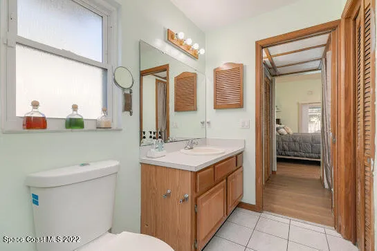 a bathroom with a sink a toilet and a large mirror