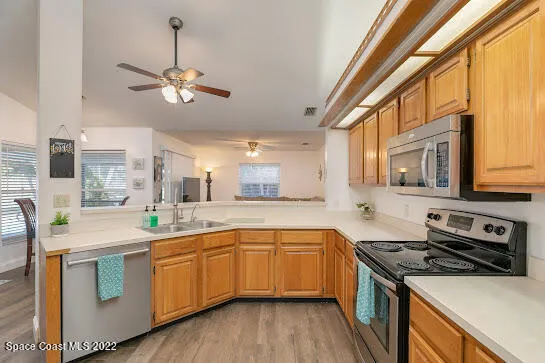 a kitchen with a sink appliances a counter space and a window