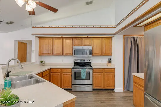 a kitchen with stainless steel appliances a stove a sink and a refrigerator