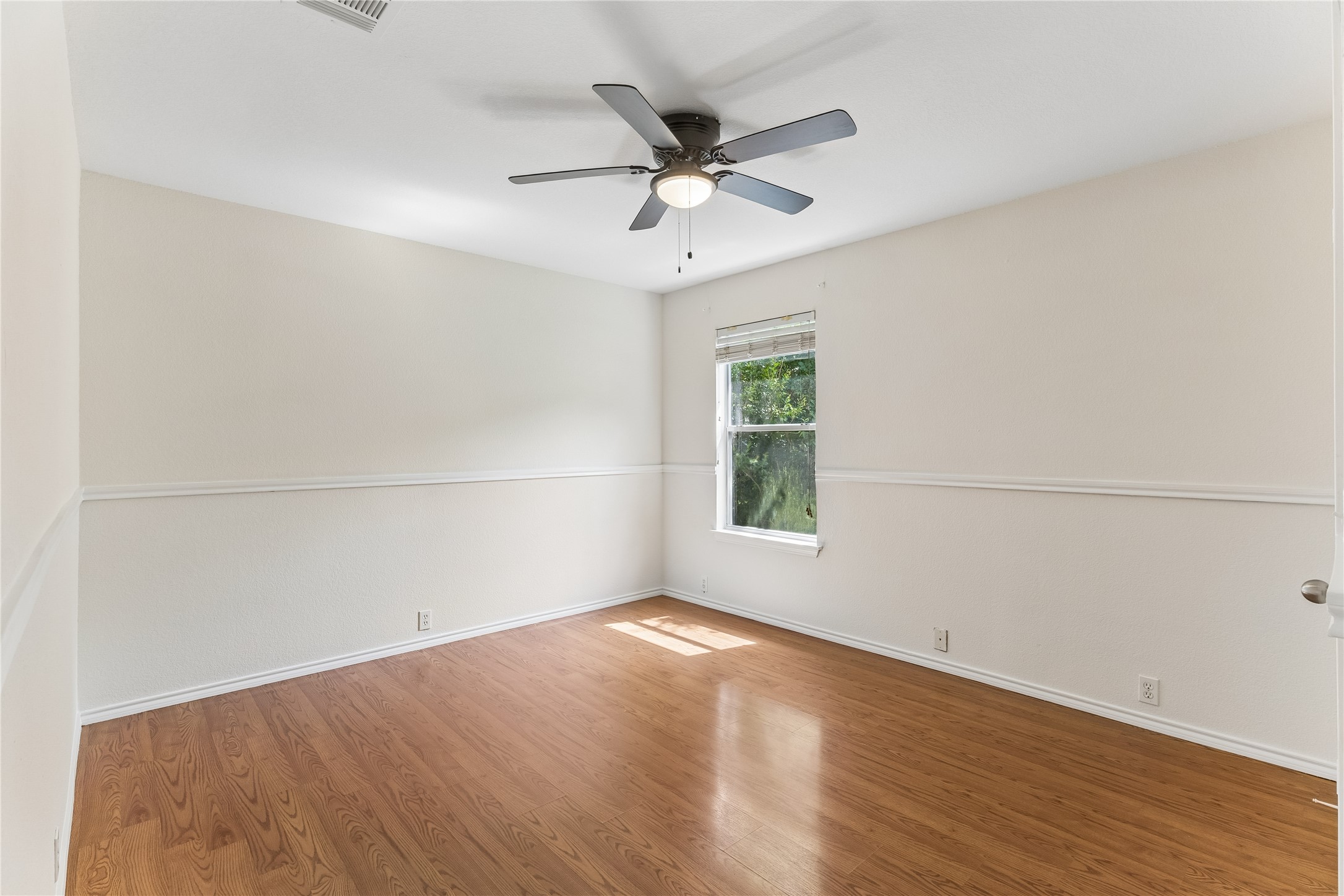 2372 Paradise Ridge Drive Round Rock, TX 78665 - Photo 35 of 40 Hardwood floors and a bright window elevate this comfortable bedroom space.