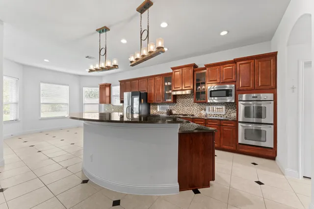 a kitchen with stainless steel appliances kitchen island granite countertop a sink and cabinets