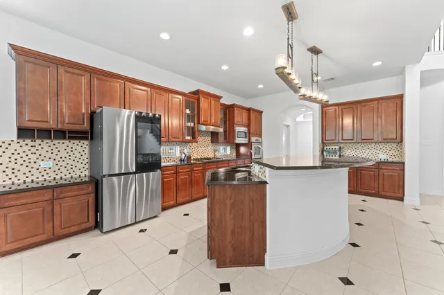 a kitchen with stainless steel appliances granite countertop a refrigerator and a sink