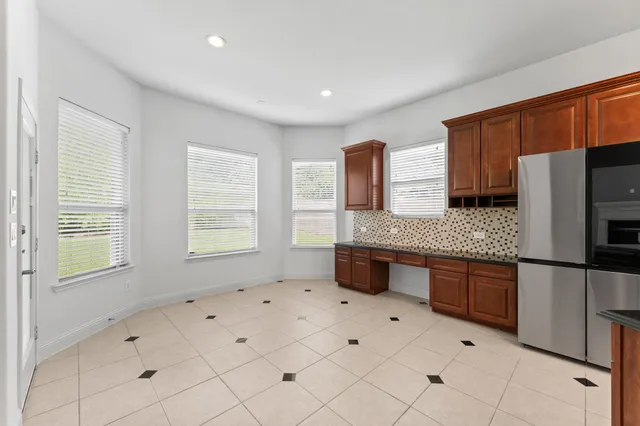 a large kitchen with granite countertop a stove a sink a refrigerator a counter space and cabinets