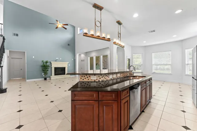a kitchen with stainless steel appliances kitchen island granite countertop a stove a sink and a refrigerator