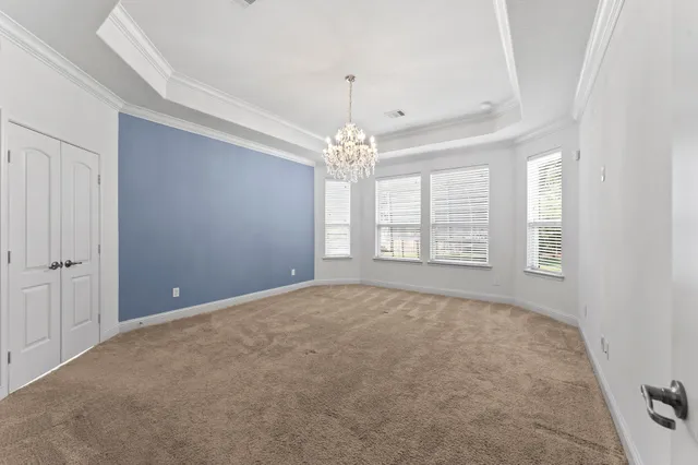 a view of an empty room with windows and chandelier