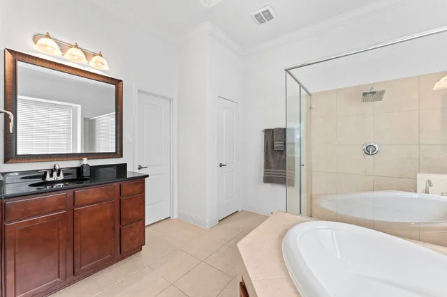 a en suite bathroom with a bathtub double sink and mirror