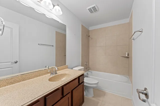 a bathroom with a granite countertop sink a toilet and shower