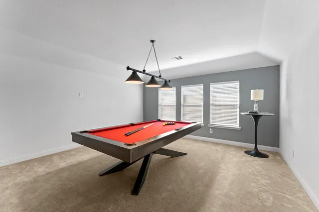 a room with pool table and windows