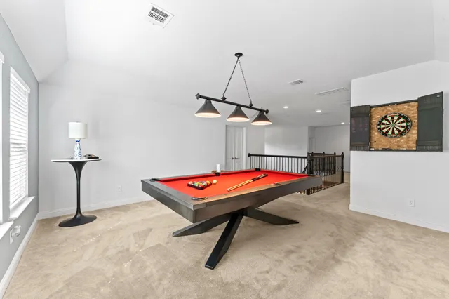 a room with pool table and windows
