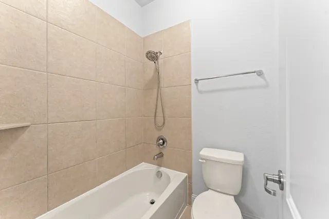 a white toilet sitting next to a bath tub and shower