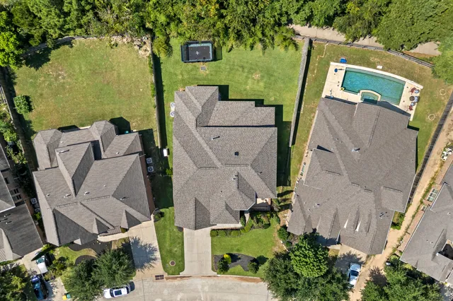 an aerial view of residential house with outdoor space and trees all around