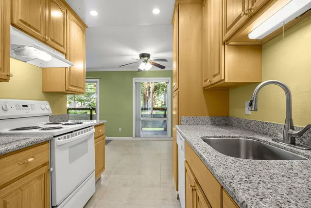 a kitchen with a sink a stove and cabinets