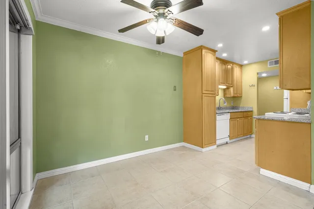 a view of a kitchen with a refrigerator a ceiling fan and a kitchen view