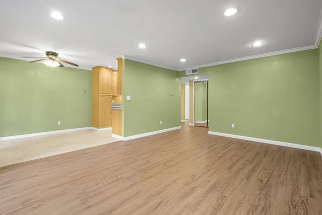 a view of empty room with wooden floor
