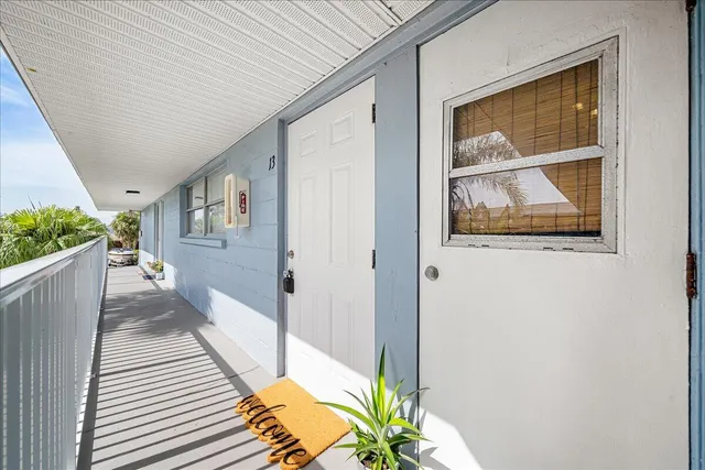 a view of a hallway with wooden floor and a potted plant