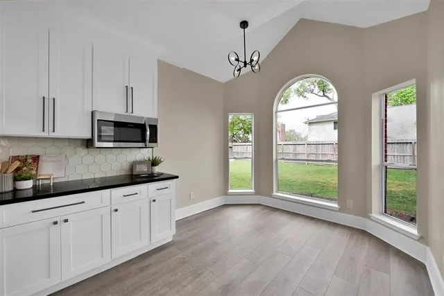 a kitchen with granite countertop a stove a sink a window and cabinets