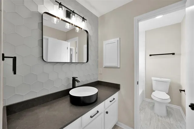 a bathroom with a toilet sink and mirror