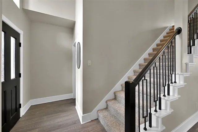 an entryway with wooden floor and stairs