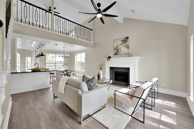 a living room with furniture a fireplace and a chandelier