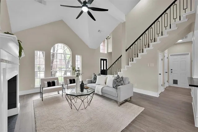 a living room with fireplace furniture and a large window