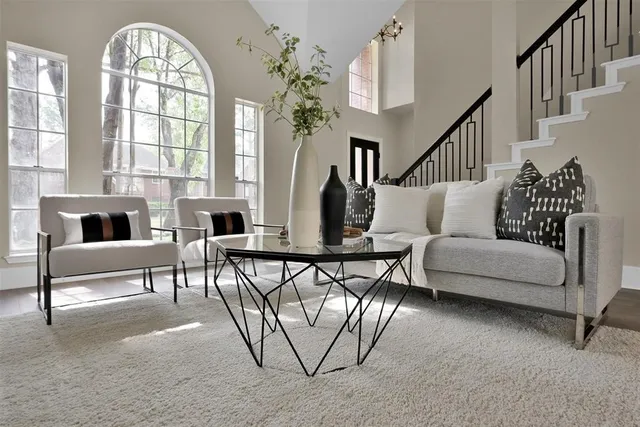 a living room with furniture a dining table and a large window