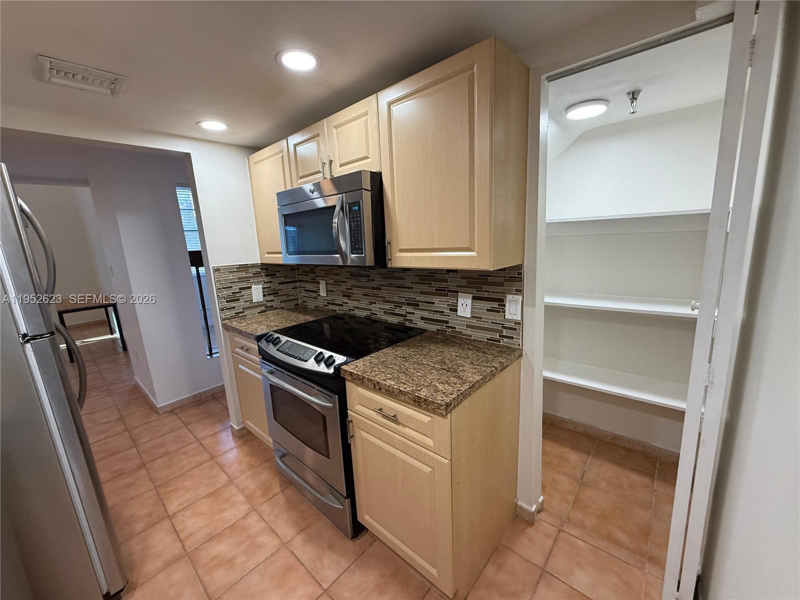 10641 Southwest 108th Avenue, Unit 3I Miami, FL 33176 - Photo 3 of 25 a kitchen with a stove microwave and a refrigerator