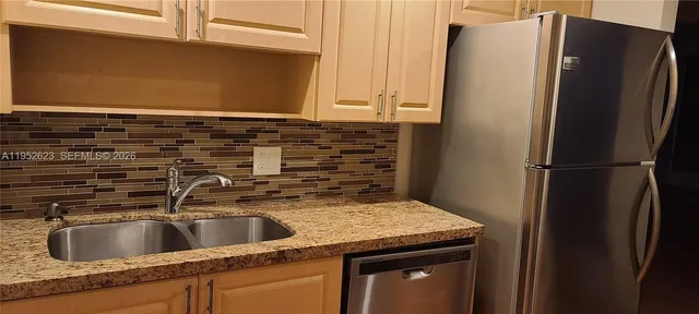 a kitchen with stainless steel appliances granite countertop a refrigerator and a sink