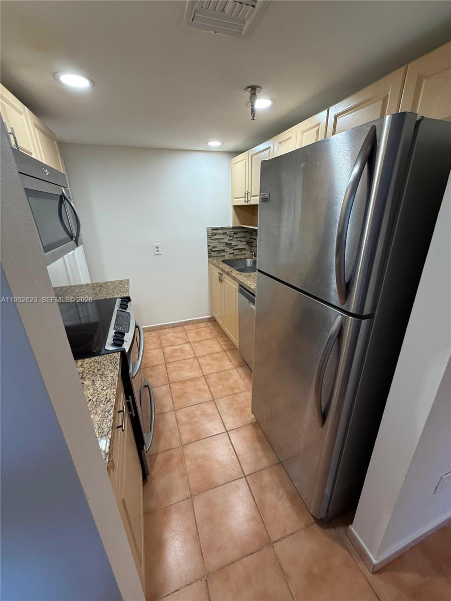 10641 Southwest 108th Avenue, Unit 3I Miami, FL 33176 - Photo 4 of 25 a kitchen with stainless steel appliances granite countertop a refrigerator and a sink