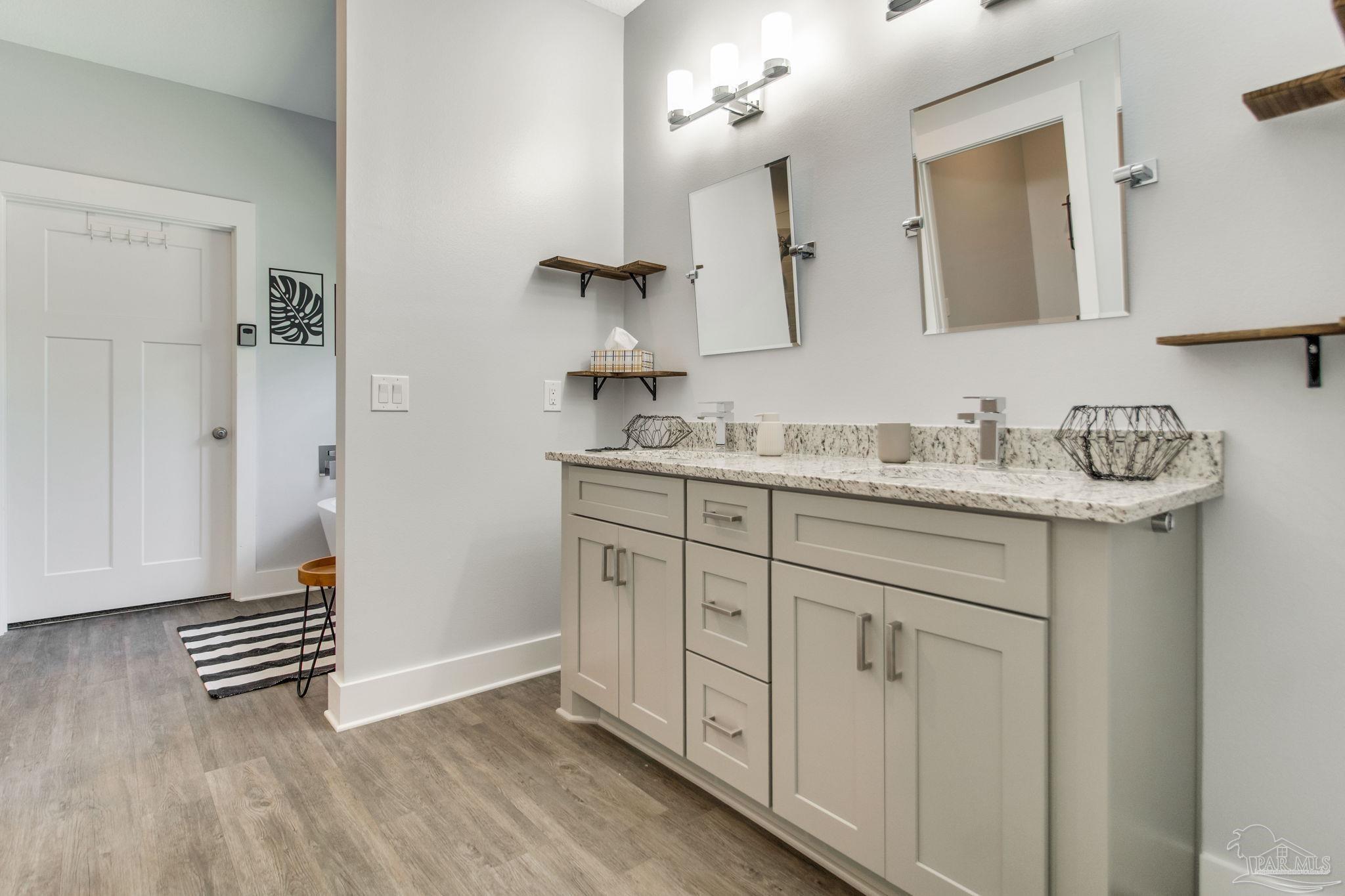 8245 Verano Street Navarre, FL 32566 - Photo 21 of 72 a spacious bathroom with a sink a mirror and a shower