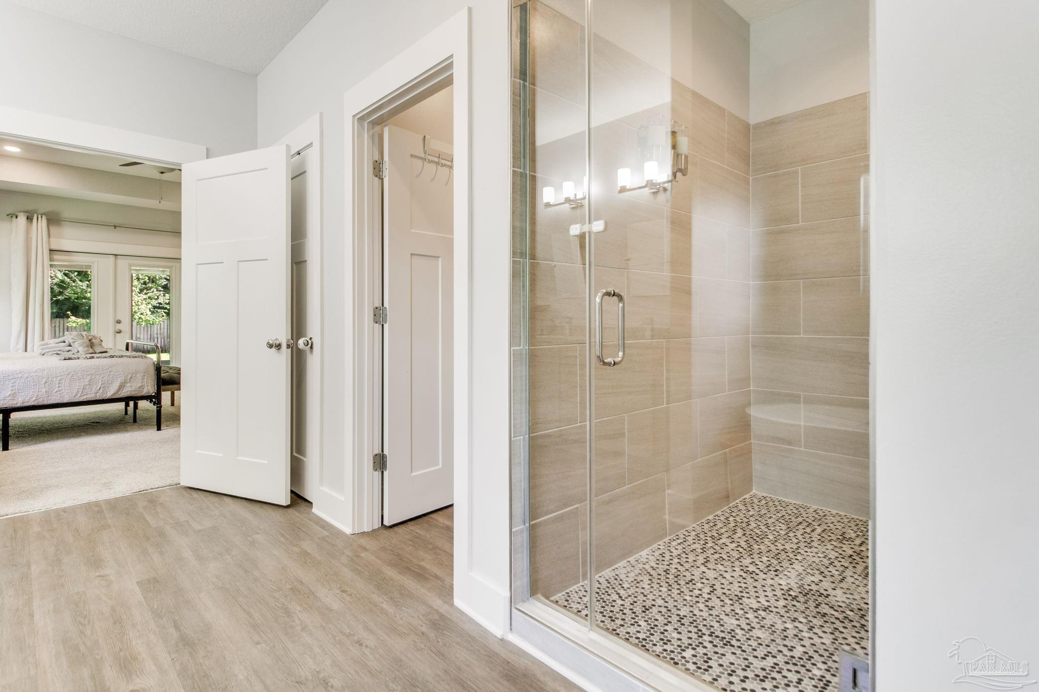 8245 Verano Street Navarre, FL 32566 - Photo 25 of 72 a bathroom with a glass shower door and a bathtub