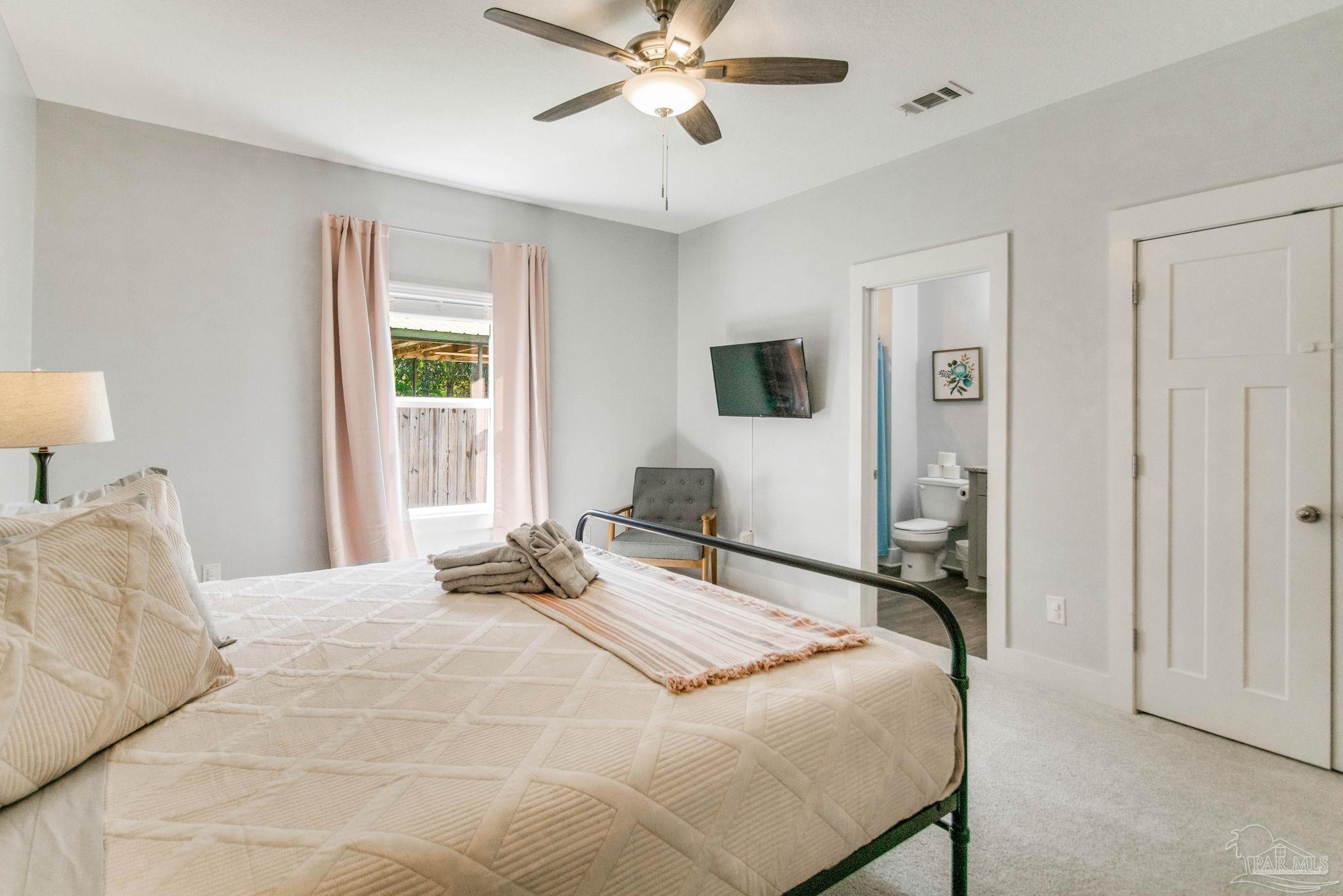 8245 Verano Street Navarre, FL 32566 - Photo 33 of 72 a bedroom with a bed window and a chandelier