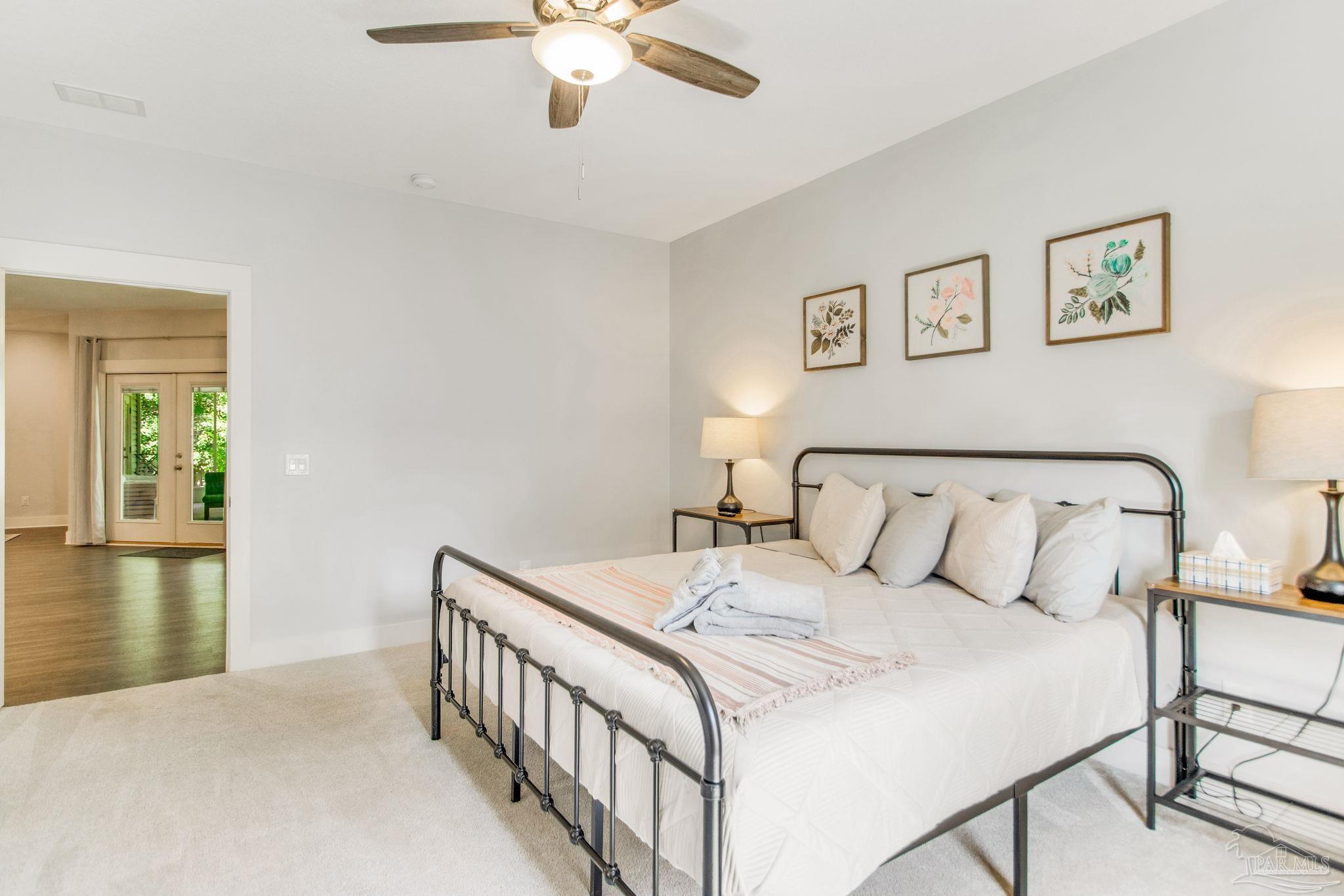 8245 Verano Street Navarre, FL 32566 - Photo 34 of 72 a bedroom with a large bed and a chandelier