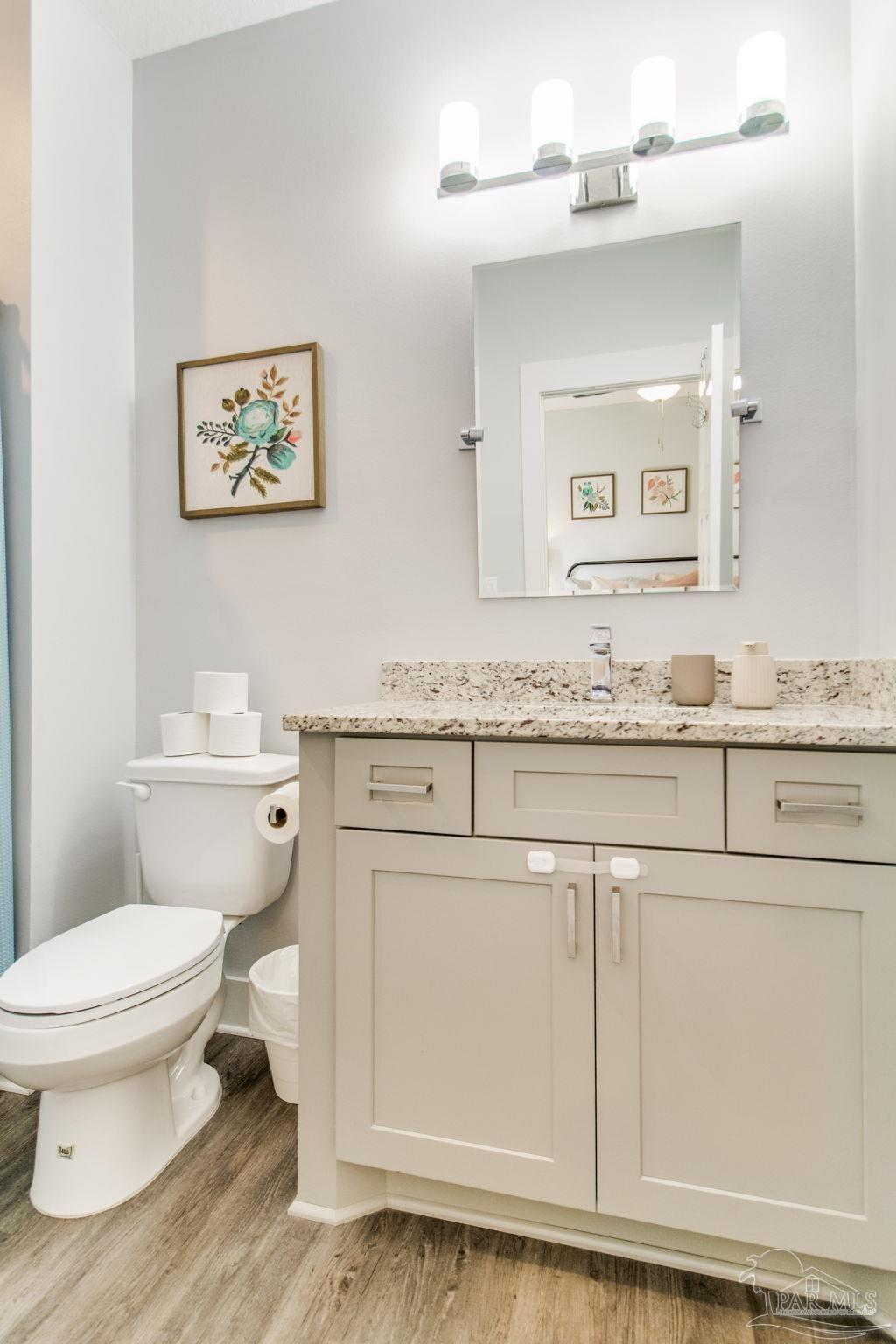 8245 Verano Street Navarre, FL 32566 - Photo 37 of 72 a bathroom with a granite countertop toilet sink and mirror