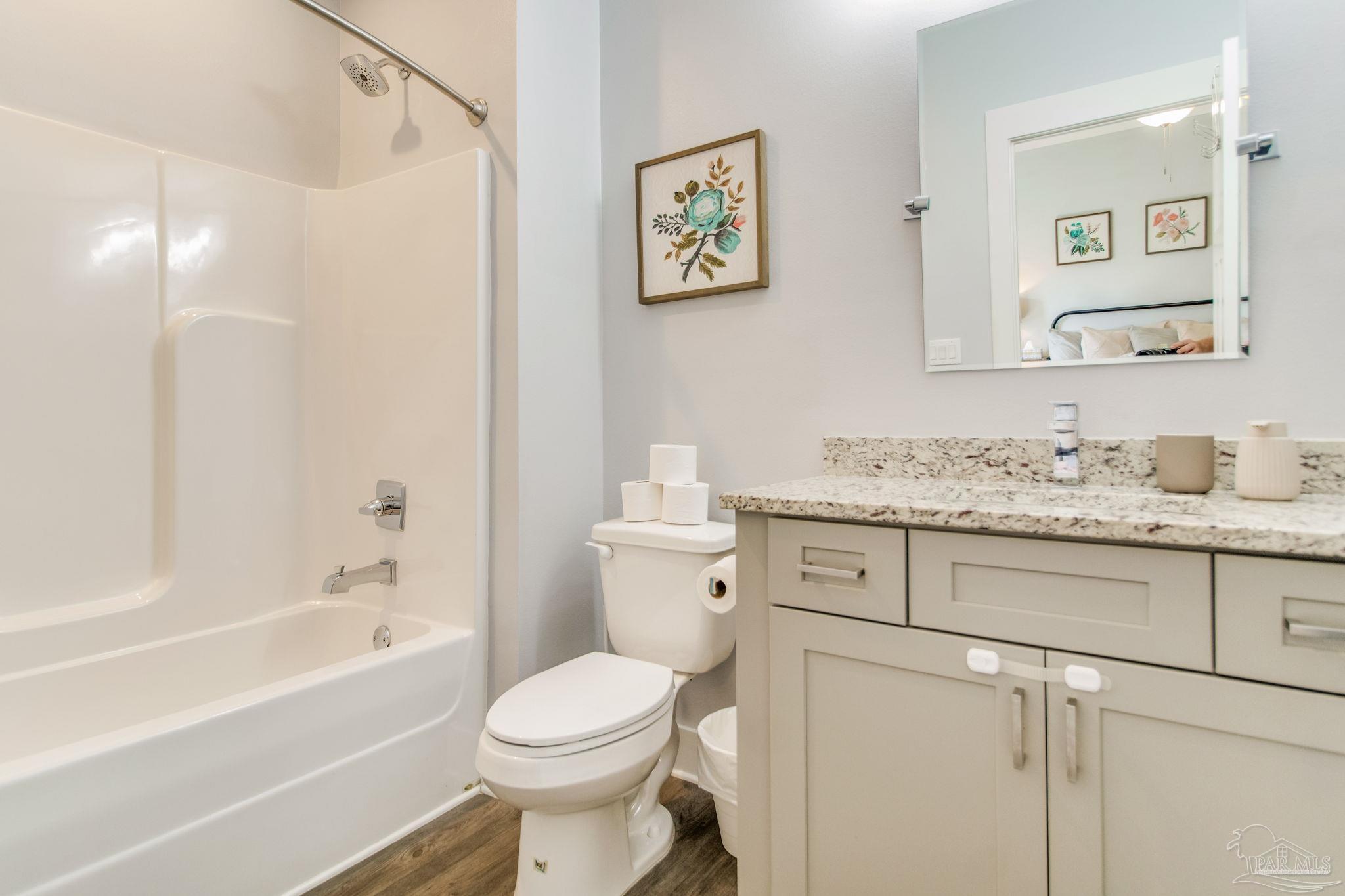 8245 Verano Street Navarre, FL 32566 - Photo 38 of 72 a bathroom with a granite countertop toilet sink and a bathtub