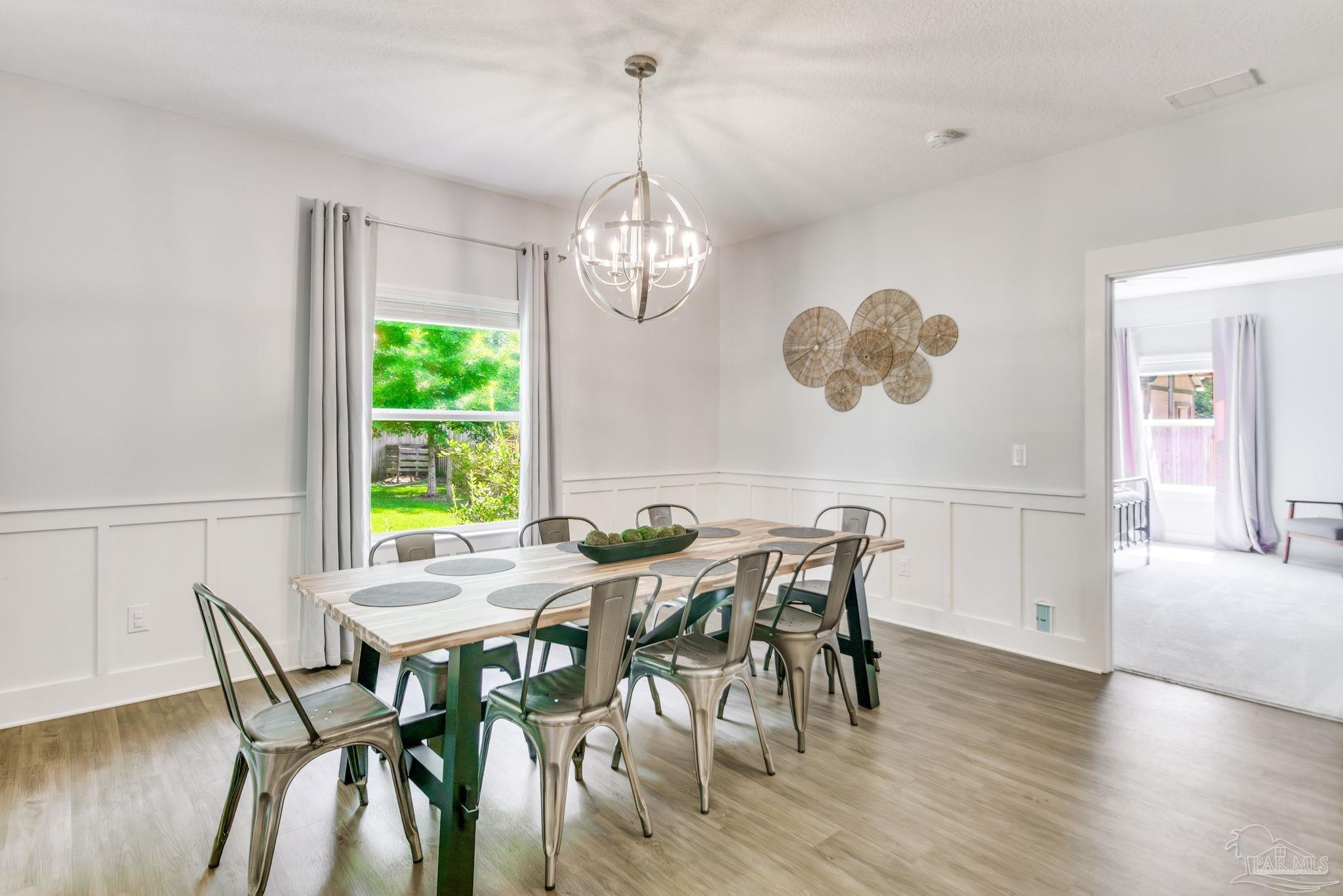 8245 Verano Street Navarre, FL 32566 - Photo 55 of 72 a view of a dining room with furniture window and wooden floor