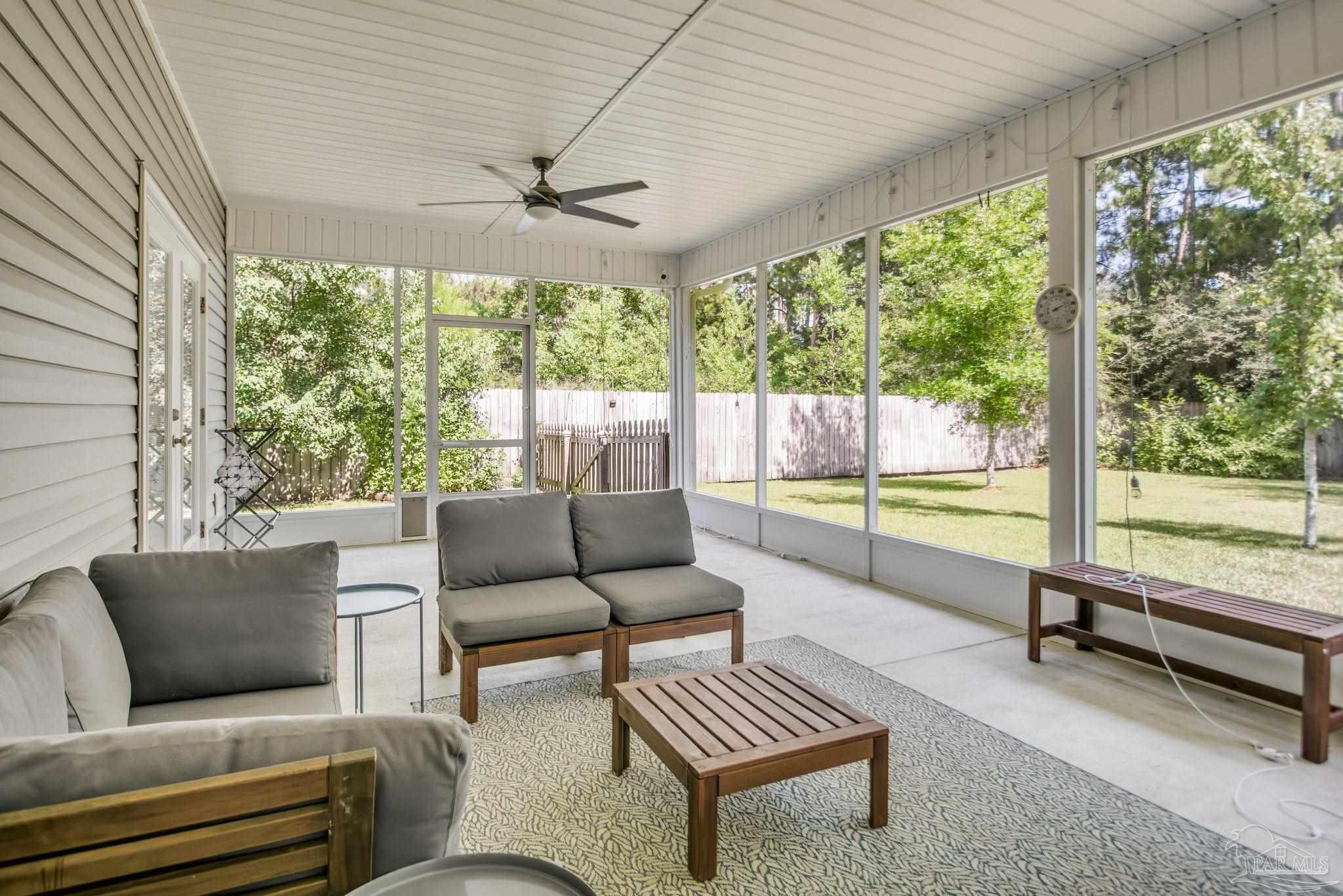 8245 Verano Street Navarre, FL 32566 - Photo 59 of 72 a living room with furniture and a floor to ceiling window
