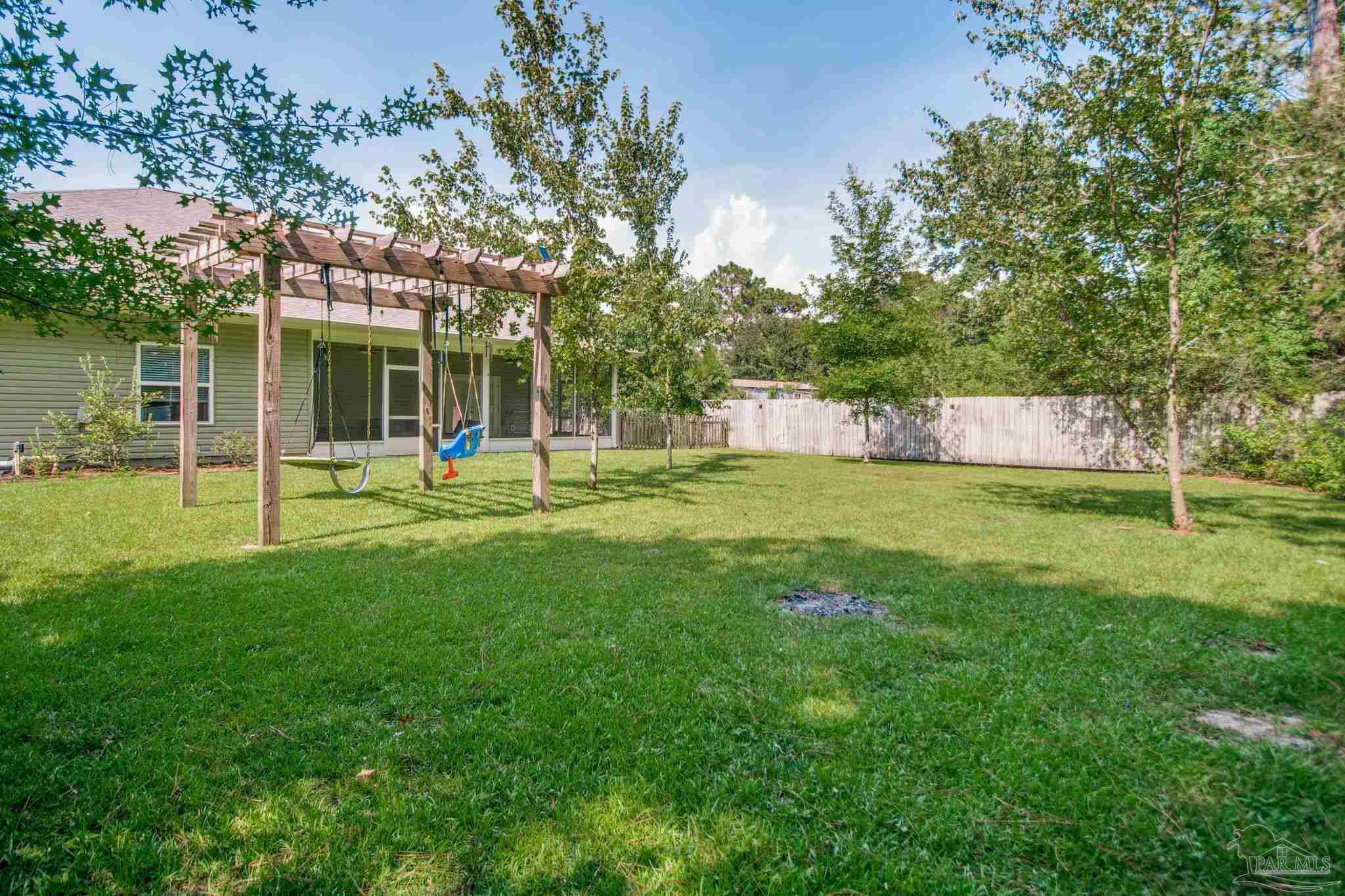 8245 Verano Street Navarre, FL 32566 - Photo 71 of 72 a view of a house with a backyard