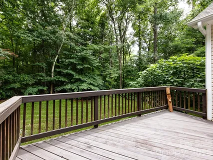 a balcony with wooden floor and trees in the back