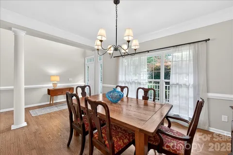 a dining room with furniture a chandelier and wooden floor