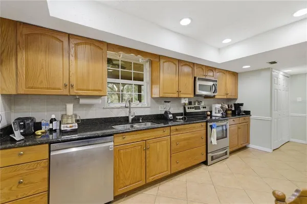 a kitchen with stainless steel appliances granite countertop a stove a sink and a microwave