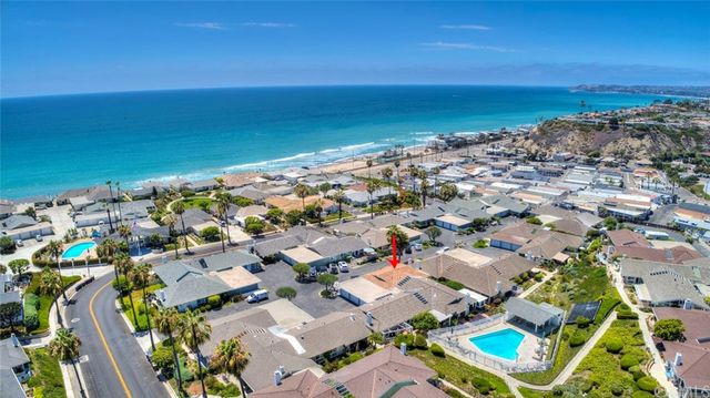 an aerial view of a city with ocean view in back