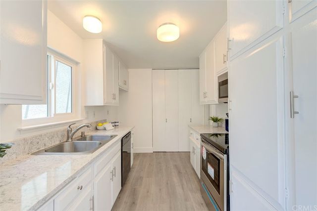 a kitchen with a sink a stove and cabinets