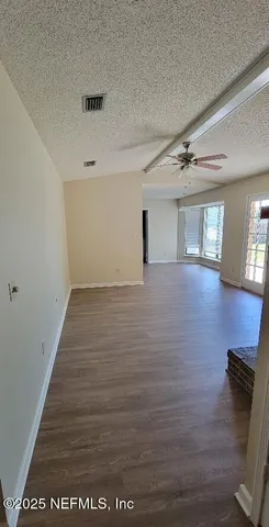 a view of an empty room with wooden floor